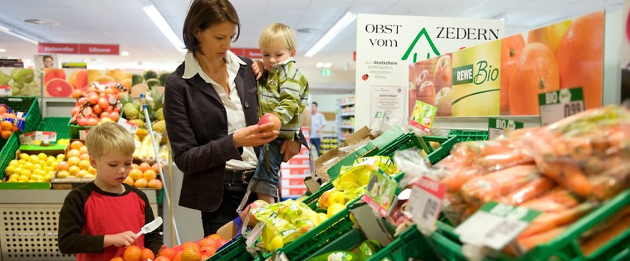 Eine Familie beim Einkauf an Gemüsetheke